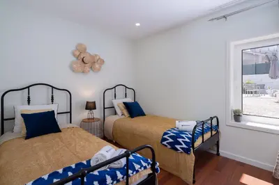 a bedroom with two beds and a window at OportoHost Dragão Duplex in Porto