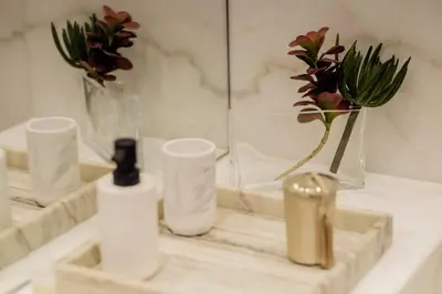 a bathroom counter with a sink with bottles and flowers at BOUTIQUE Rentals- Art & Charm Apt w/ balcony & garage in Porto