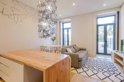 a kitchen and living room with a table and a couch at BOUTIQUE Rentals- Art & Charm Apt w/ balcony & garage in Porto