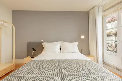 a bedroom with a large white bed with a window at YOUROPO - Flores in Porto