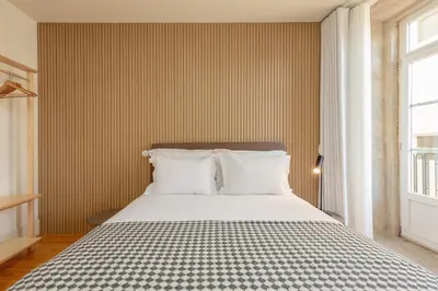 a bed with white pillows in a room with a window at YOUROPO - Flores in Porto