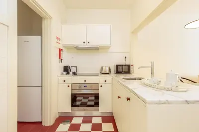a white kitchen with a sink and a refrigerator at YOUROPO - Flores in Porto