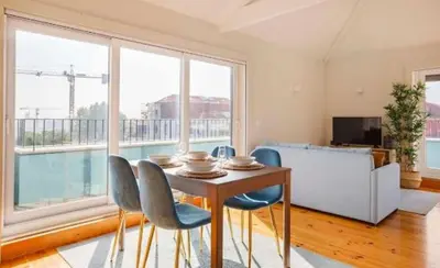 a dining room with a table and chairs and a large window at Porto Pool Spot in Porto