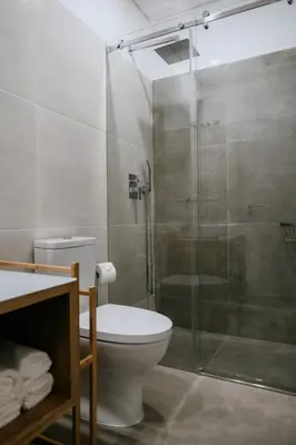 a bathroom with a toilet and a glass shower at Villa Teresa apartamentos in Vila Nova de Gaia