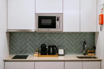 a kitchen with a sink and a microwave at Villa Teresa apartamentos in Vila Nova de Gaia