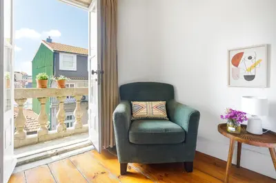 a green chair in a room with a window at Charming Historic 31 Janeiro Street in Porto