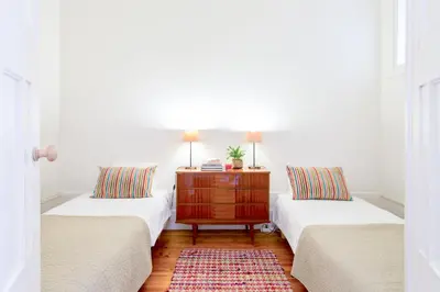 two beds in a room with a dresser between them at Charming Historic 31 Janeiro Street in Porto