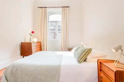 a white bedroom with a bed and a window at Charming Historic 31 Janeiro Street in Porto