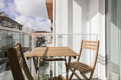 a wooden table and two chairs on a balcony at Nomad's Easy Stay - 1BED Porto Marquês in Porto
