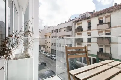 a chair on a balcony with a view of a city at Nomad's Easy Stay - 1BED Porto Marquês in Porto