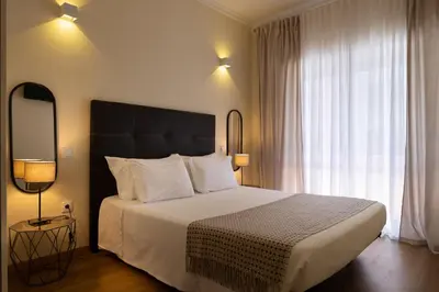 a bedroom with a large bed and a large window at Bolhão Apartment in Porto