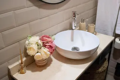 a bathroom with a sink and flowers on a counter at Bolhão Apartment in Porto