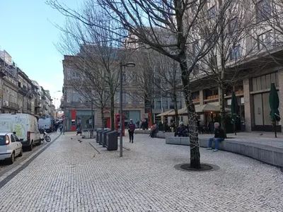 a city street with trees and people walking on a sidewalk at Bolhão Apartment in Porto