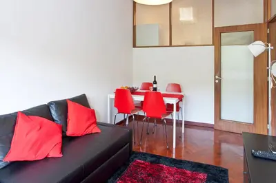 a living room with a couch and a table with red chairs at O´Porto Torrinha Flat in Porto