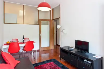 a living room with red chairs and a television at O´Porto Torrinha Flat in Porto