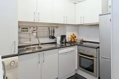 a kitchen with white cabinets and a sink at O´Porto Torrinha Flat in Porto