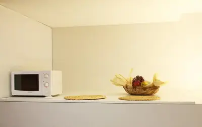 a microwave and a bowl of fruit on a counter at O´Porto Outeiro Flat in Porto