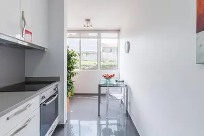 a kitchen with a small table and a window at O´Porto Fontinha Flat in Porto