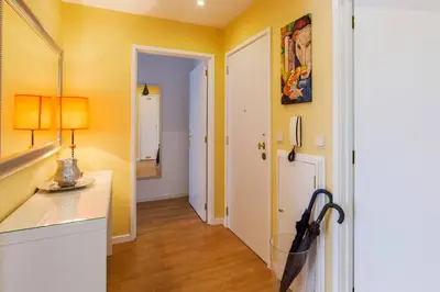 a kitchen with yellow walls and a hallway with an umbrella at O´Porto Fontinha Flat in Porto