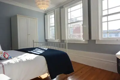 a bedroom with a bed with blue walls and windows at Bonjardim 466 - Historic Townhouse in Porto