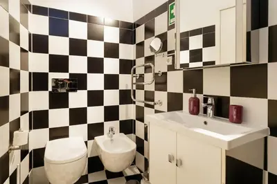a bathroom with a black and white checkered wall at Rendez Vous Porto II in Porto