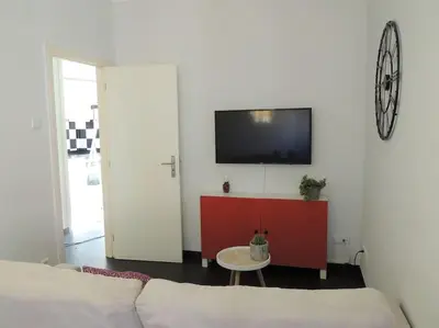 a living room with a couch and a tv on a wall at Rendez Vous Porto II in Porto