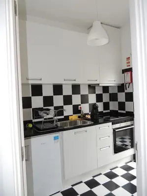 a kitchen with a black and white checkered floor at Rendez Vous Porto II in Porto