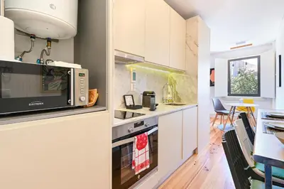 a kitchen with white cabinets and a microwave at ON Apartments - Garden View 2 in Porto