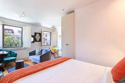 a bedroom with a bed and chairs and a window at ON Apartments - Garden View 2 in Porto