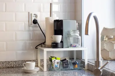 a kitchen counter with a coffee maker on a table at Alto da Lapa House w Parking by LovelyStay in Porto