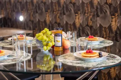 a glass table topped with plates of food and drinks at Alto da Lapa House w Parking by LovelyStay in Porto