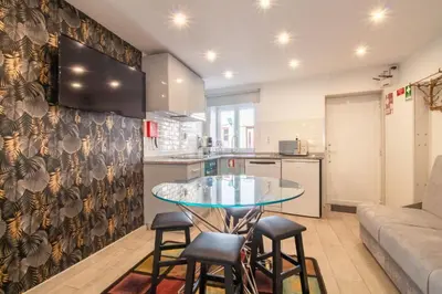 a kitchen and living room with a glass table and stools at Alto da Lapa House w Parking by LovelyStay in Porto