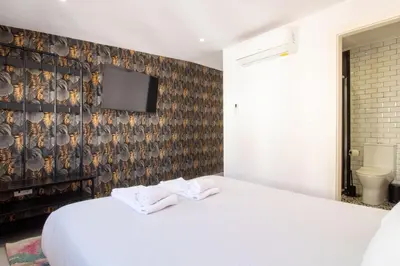 a bedroom with a white bed and a tv on a wall at Alto da Lapa House w Parking by LovelyStay in Porto