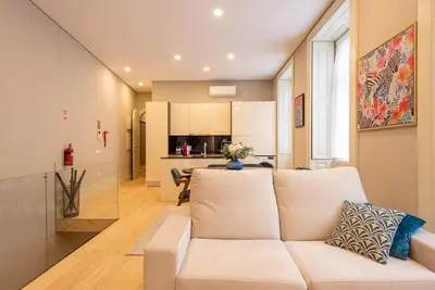 a living room with a white couch and a kitchen at CC Downtown Palace - A in Porto