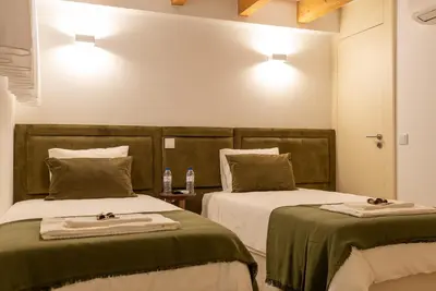 a bedroom with two beds with green covers and lights at CC Downtown Palace - D in Porto