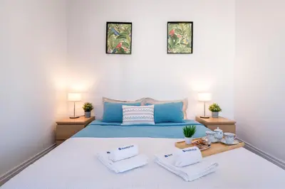 a bedroom with a blue bed with two pillows at Host Wise - Spacious Comfortable Apartment - Balcony in Porto