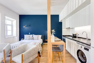 a bedroom with a bed with a blue wall at DA'HOME - Boavista Blue Studio - NEW in Porto
