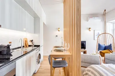 a kitchen and living room with a table and a couch at DA'HOME - Boavista Blue Studio - NEW in Porto