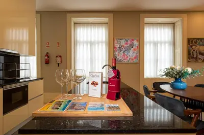 a kitchen with a counter with wine glasses and a table at CC Downtown Palace - E in Porto