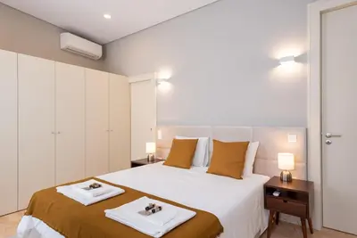 a bedroom with a large bed with two towels on it at CC Downtown Palace - E in Porto