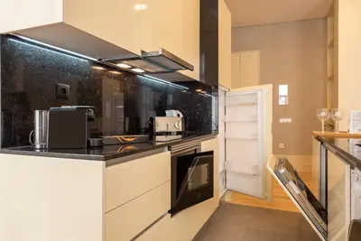 a kitchen with white cabinets and black counter tops at CC Downtown Palace - H in Porto