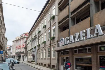 a building with a sign on it on a city street at CC Downtown Palace - J in Porto