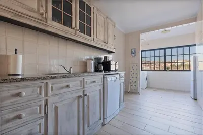 a kitchen with white cabinets and white appliances at MyRiverPlace River View Porto apartments in Vila Nova de Gaia