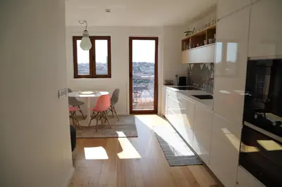 a kitchen with white cabinets and a table with chairs at Casa do Pilar - D Maria Pia in Vila Nova de Gaia