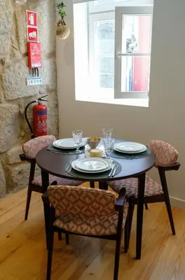a dining room table with plates and glasses on it at Adega Floresta Residence in Porto