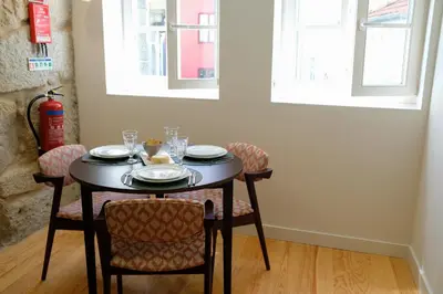 a table with chairs and plates and glasses on it at Adega Floresta Residence in Porto