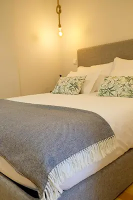 a bedroom with a large bed with white sheets and pillows at Adega Floresta Residence in Porto