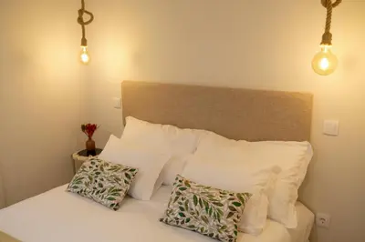 a bedroom with a bed with white pillows and lights at Adega Floresta Residence in Porto