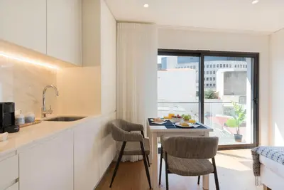 a kitchen and dining room with a table and chairs at LovelyStay - Heart of D. Pedro Apartments IV in Porto