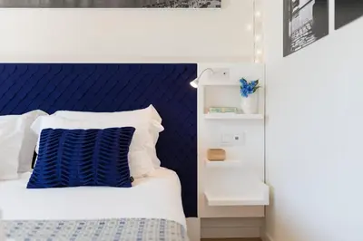 a bed with a blue headboard and white pillows at LovelyStay - Heart of D. Pedro Apartments IV in Porto